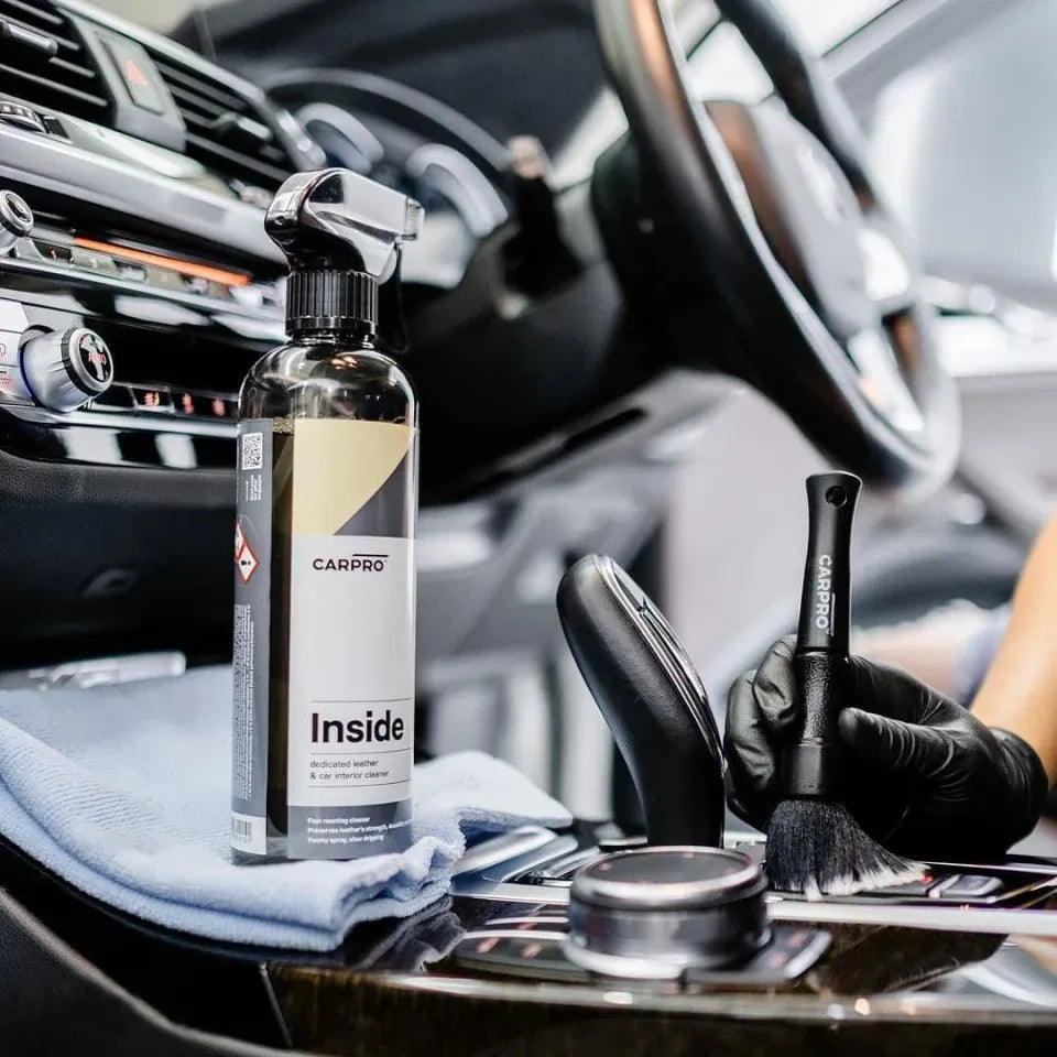 Planet Car Care CarPro Inside 500ml cleaner being used with a detailing brush on a car interior console