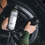 Planet Car Care user applying CarPro Perl water-based dressing to a car tire with a detailing brush for UV protection.