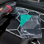 Planet Car Care CarPro Rayon Glass Polishing Pad in packaging held by gloved hand near a buffer on a car windshield