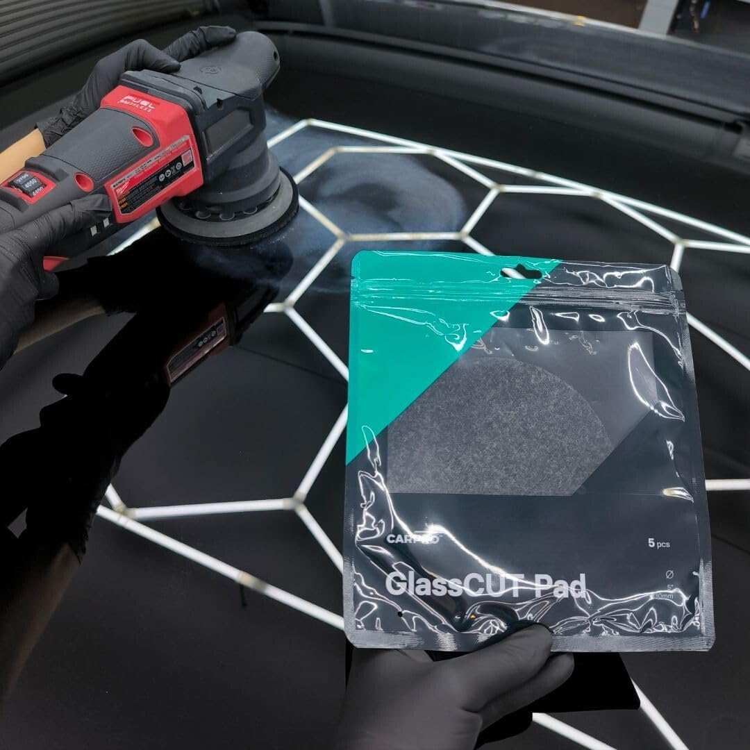 Planet Car Care CarPro Rayon Glass Polishing Pad in packaging held by gloved hand near a buffer on a car windshield