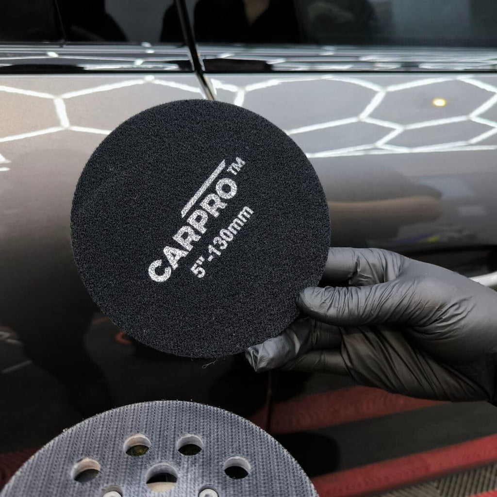 Planet Car Care CarPro 130mm rayon glass polishing pad held in a gloved hand for automotive detailing