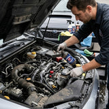 Planet Car Care professional using Ultimate Degreaser to clean a car engine bay with a brush and spray bottle