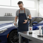 Planet Car Care EraseX Panel Preparation Spray bottle on a workshop table with a detailer in the background