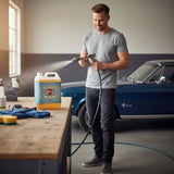 Planet Car Care Foam Fury snow foam shampoo 5L bottle on a workbench with a man using a foam cannon on a car