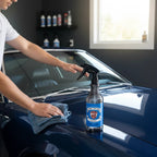 Planet Car Care Glassify glass cleaner spray bottle being used to clean a blue car windshield with a microfiber cloth