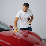 Man applying Planet Car Care Hyper Gloss liquid wax to the hood of a red car using a yellow foam applicator pad