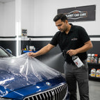Technician using Planet Car Care PPF Tack Solution spray to apply paint protection film to a blue car hood