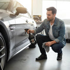 Man using Planet Car Care tar and glue remover spray on a grey car exterior in a professional detailing garage