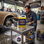 Planet Car Care technician using a foaming degreaser on a car wheel in a professional auto detailing workshop.