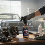 Planet Car Care Ultimate Degreaser spray bottle on a workshop table next to a car brake disc and tools