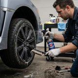 Planet Car Care Ultimate Degreaser being sprayed on a car wheel by a professional detailer using a cleaning brush.